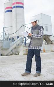 male architect standing near a factory outdoors