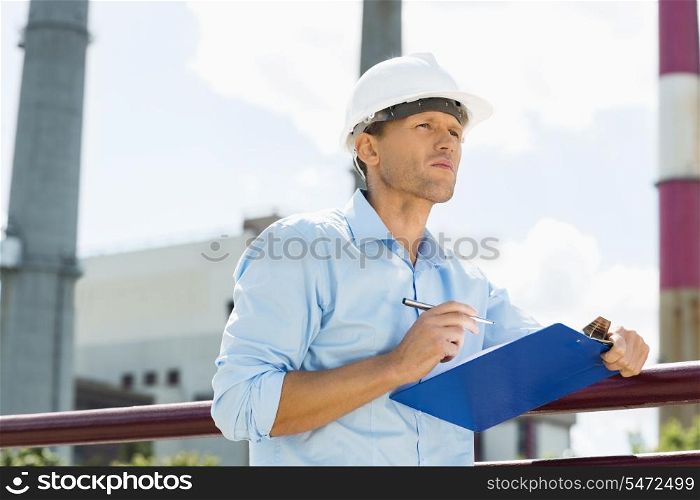 Male architect with clipboard and pen at site