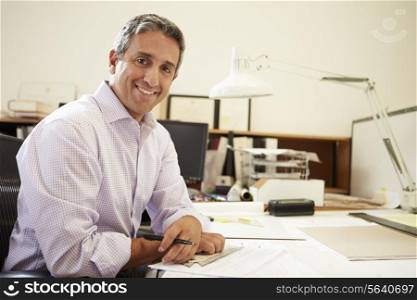 Male Architect Working At Desk In Office