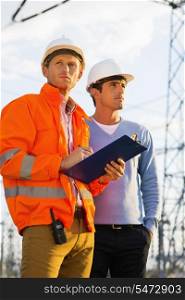 Male architects with clipboard inspecting site together
