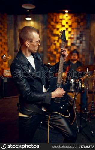 Male artist with electric guitar, music performing on stage. Rock band performance or repetition in garage, man with string musical instrument, live sound performer. Male artist with electric guitar, music performing