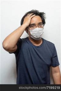 Male Asian patient wearing surgical mask feeling sick headache and coughing isolated on white background.Wuhan coronavirus (COVID-19) outbreak prevention. Health care concept