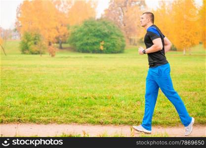 Male athlete jogging in the morning in the park