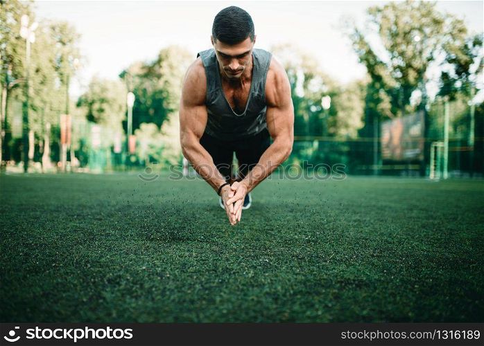 Male athlete on training, push-up exercise in action, fitness workout. Sportsman in park. Athlete on training, push-up exercise in action