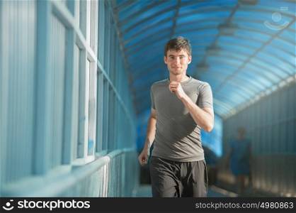 Male athlete/runner running in city - jog workout wellbeing concept