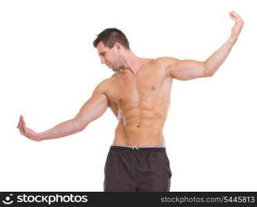 Male athlete with muscular body gracefully posing