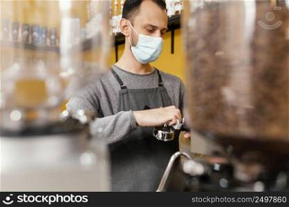 male barista cleaning professional coffee machine