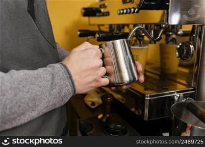 male barista frothing milk