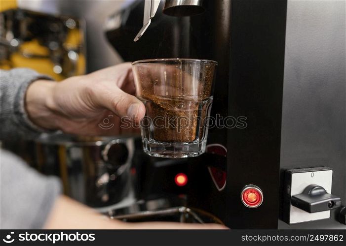 male barista grinding coffee with machine