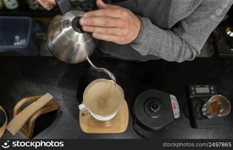 male barista pouring boiling water coffee filter