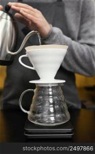 male barista pouring water coffee filter