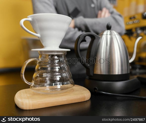 male barista preparing coffee with kettle filter
