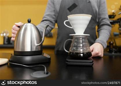 male barista with apron kettle