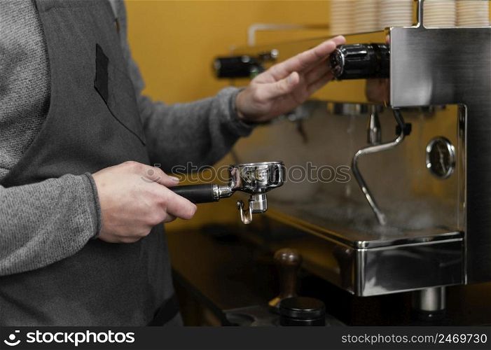 male barista with apron using professional coffee machine