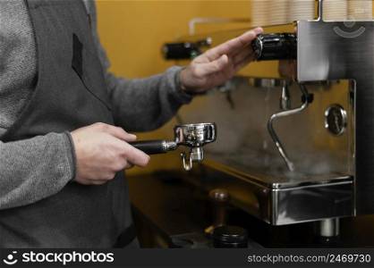 male barista with apron using professional coffee machine