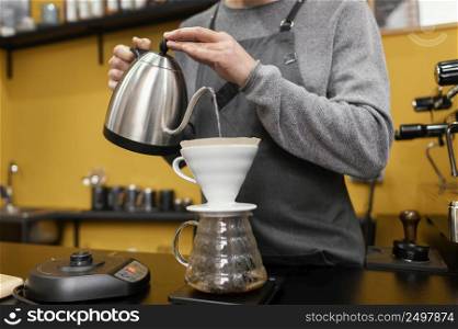 male barista with pouring water coffee filter