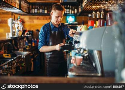 Male bartender prepares drink at the bar counter. Barkeeper occupation, barman working in pub. Male bartender prepares drink at the bar counter