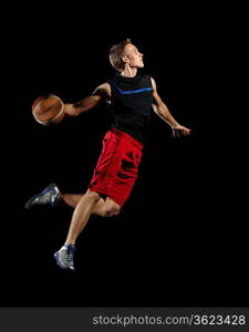 Male basketball player jumping and practicing with a ball