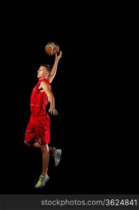 Male basketball player jumping and practicing with a ball