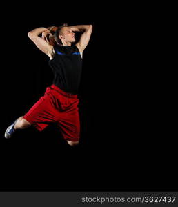 Male basketball player jumping and practicing with a ball