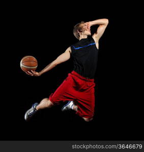 Male basketball player jumping and practicing with a ball