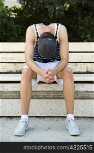 Male basketball player taking a break on park bench