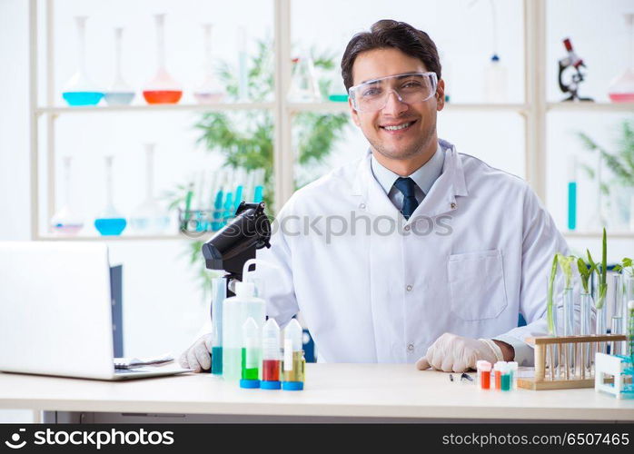 Male biochemist working in the lab on plants