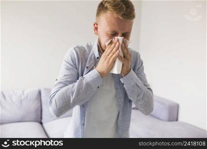 male blowing nose while having cold