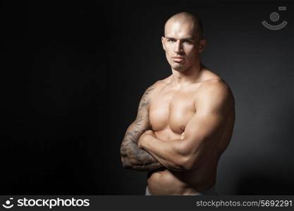 male bodybuilder with folded arms isolated on gray background with copyspace