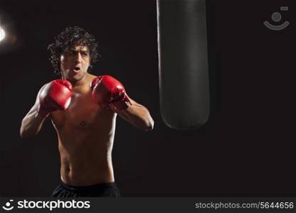 Male boxer about to hit punching bag