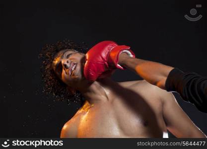 Male boxer striking opponent