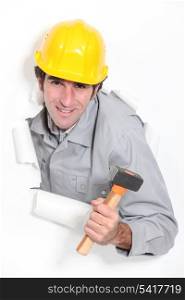 Male builder bursting through paper