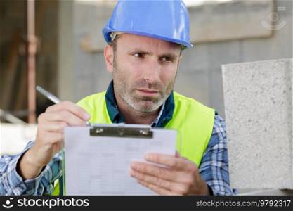 male builder checking construction papers