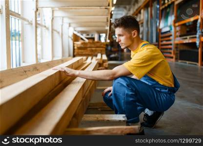 Male builder choosing repair materials in hardware store. Customer look at the goods in diy shop. Builder choosing repair materials, hardware store
