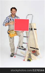 Male builder holding message board