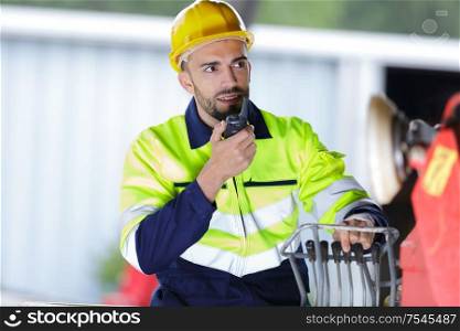 male builder in hardhat with walkie talkie outdoors