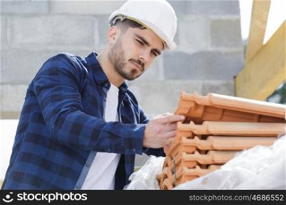 male builder is checking tiles