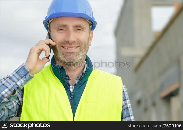 male builder talking on mobile phone outdoors