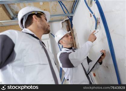 male builders checking hose pipe insulation