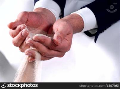 Male business hands trying to hold sand