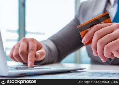 Male businessman doing online shopping with credit card. The male businessman doing online shopping with credit card