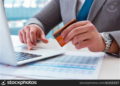 Male businessman doing online shopping with credit card. The male businessman doing online shopping with credit card
