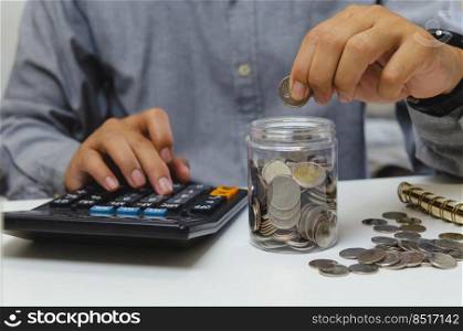 male businessman use calculator money coin financial tax and planning investments marketing economy income and retirement saving.