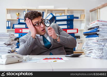 Male businessman with magnifying glass in office