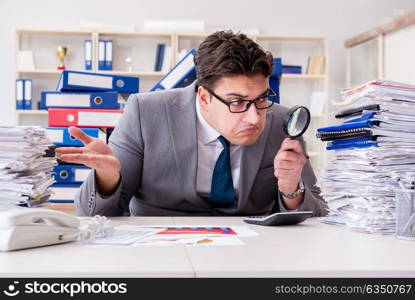 Male businessman with magnifying glass in office