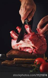 Male butcher cuts raw beef meat