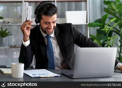 Male call center operator or telesales representative siting at his office desk wearing headset and in conversation with client providing customer service support or making persuasive sale. fervent. Male call center operator or telesales agent working on his desk. fervent