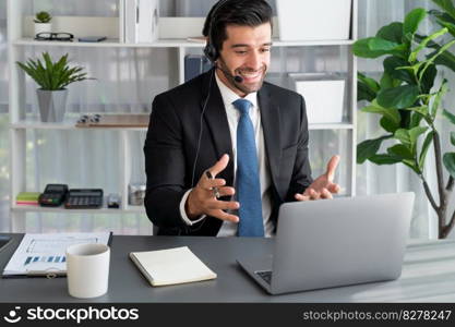 Male call center operator or telesales representative siting at his office desk wearing headset and in conversation with client providing customer service support or making persuasive sale. fervent. Male call center operator or telesales agent working on his desk. fervent