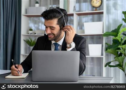 Male call center operator or telesales representative siting at his office desk wearing headset and engaged in conversation with client providing customer service support or making a sale. fervent. Male call center operator or telesales agent working on his desk. fervent