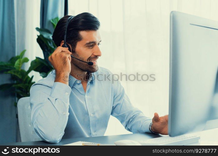 Male call center operator or telesales representative siting at his office desk wearing headset and engaged in conversation with client providing customer service support or making a sale. fervent. Male call center operator or telesales agent working on his desk. fervent